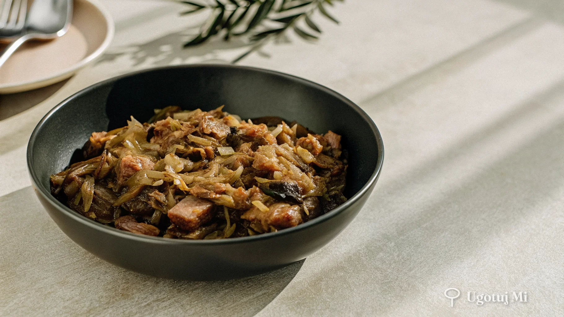 Zbliżenie na teksturę bigosu z widoczną kapustą kiszoną i kawałkami mięsa | ugotujmi.pl