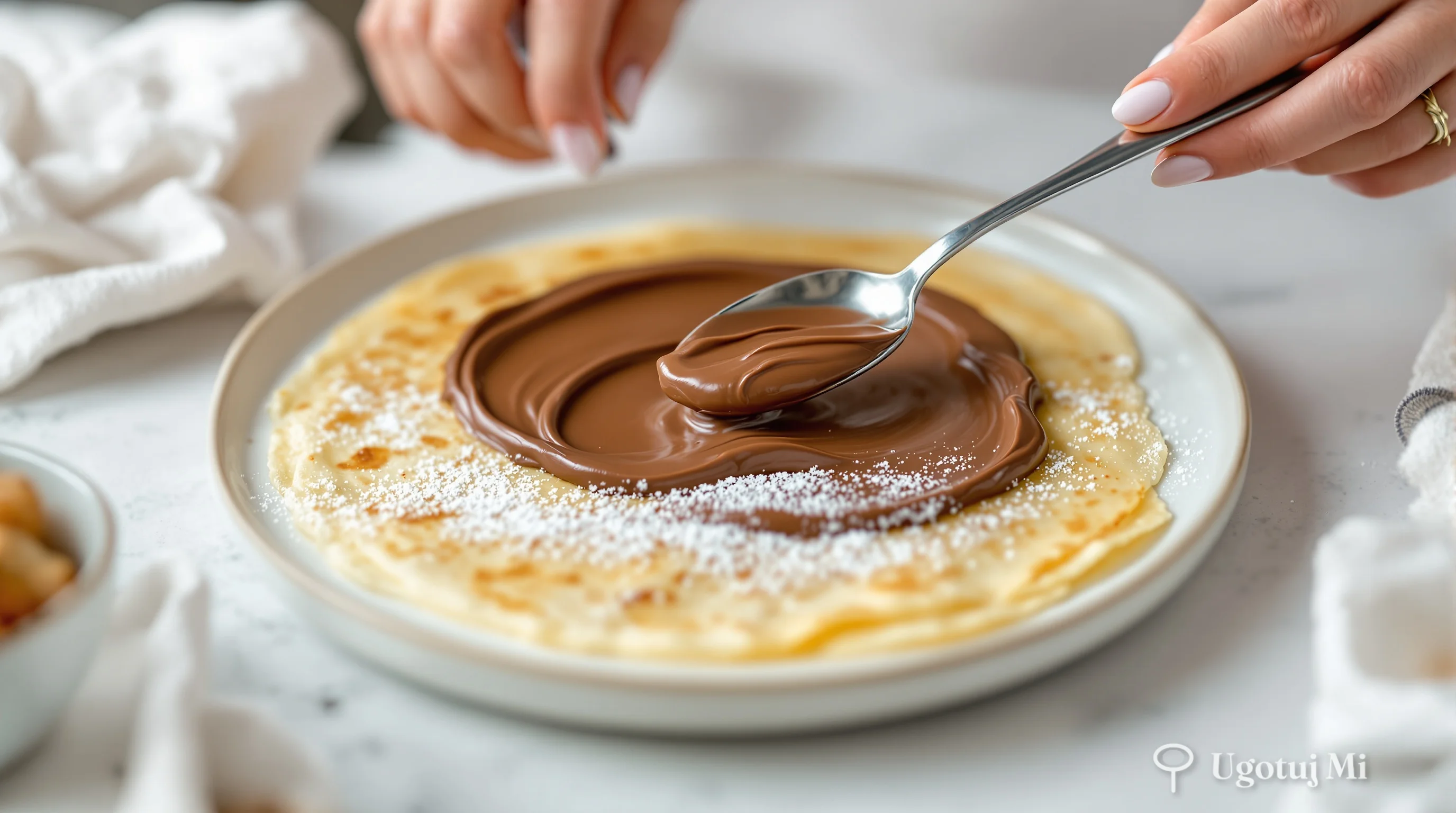 Rozsmarowywanie nutelli na cienkim naleśniku łyżką | ugotujmi.pl
