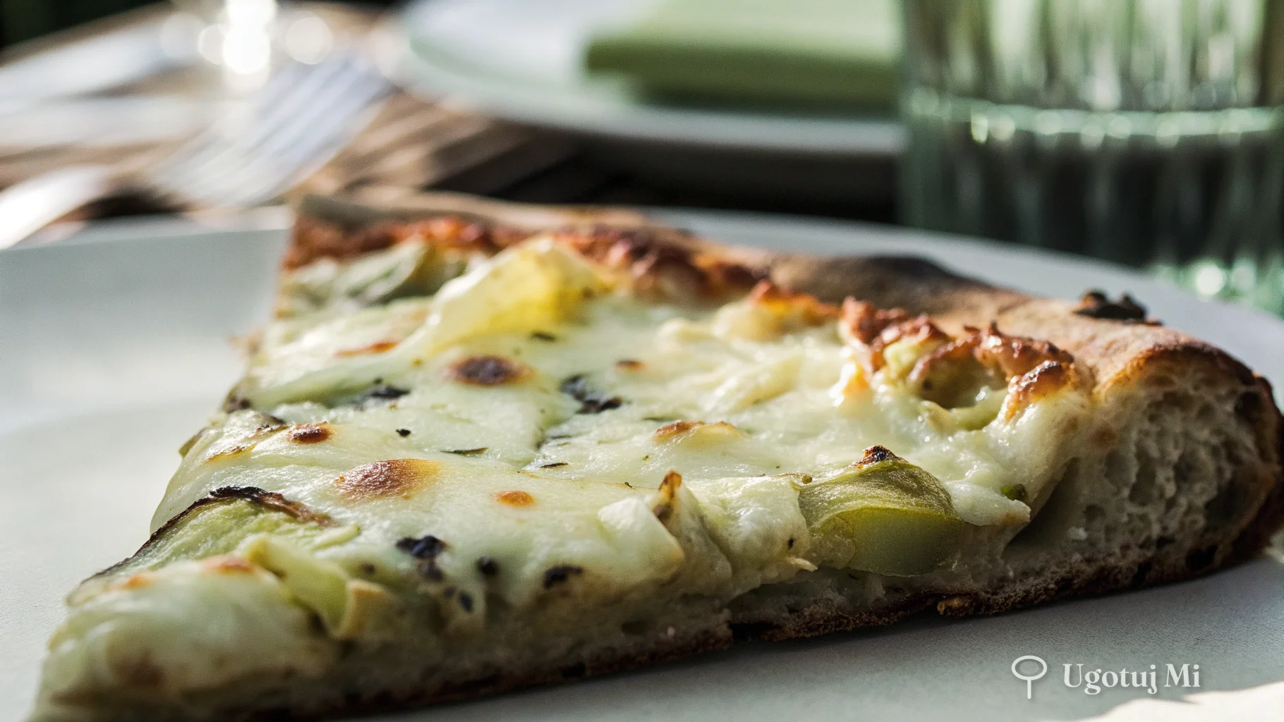 Zbliżenie na ćwiartkę pizzy z roztopioną mozzarellą i karczochami | ugotujmi.pl