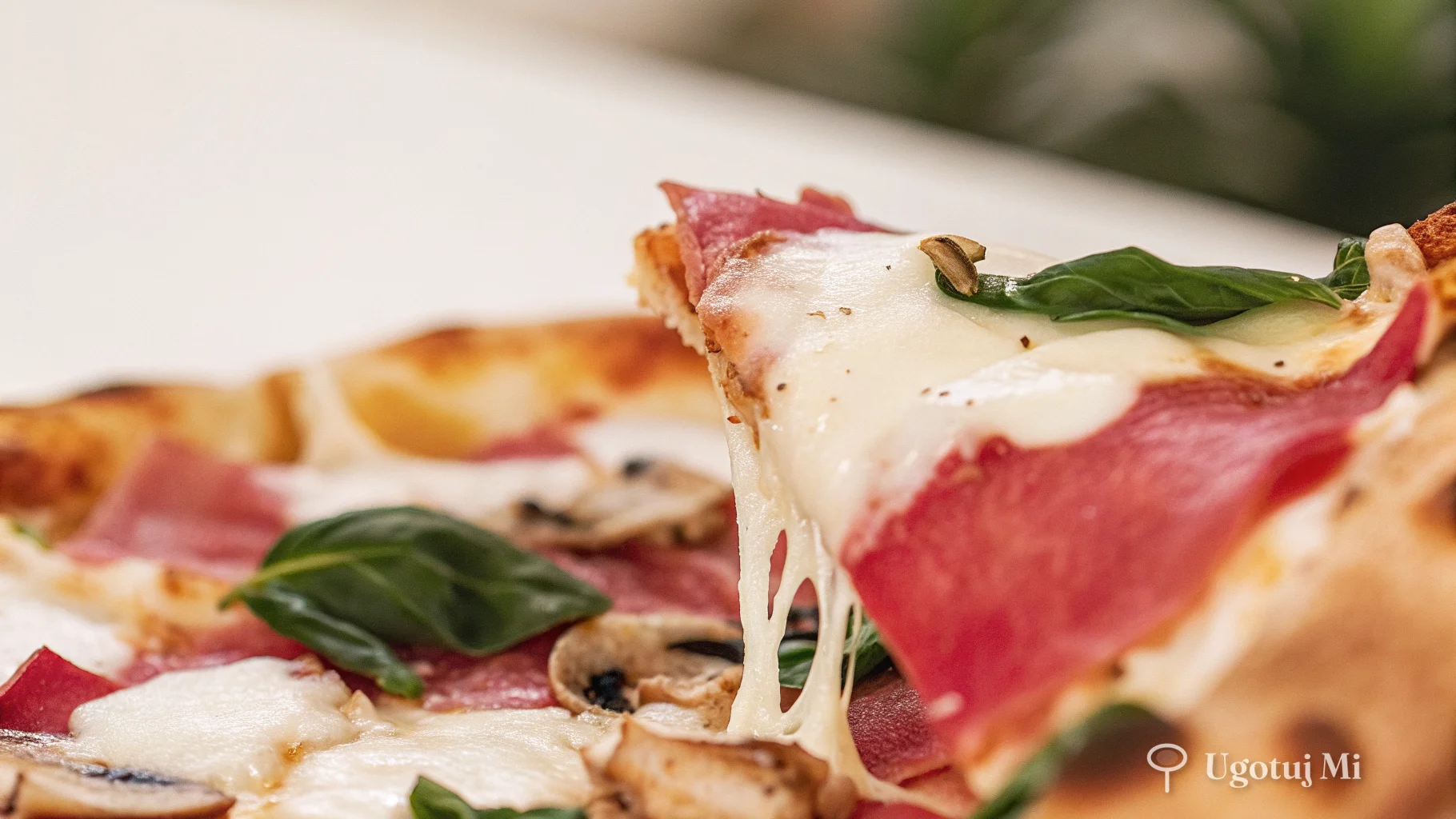 Zbliżenie na chrupiący brzeg pizzy z roztopionym serem | ugotujmi.pl