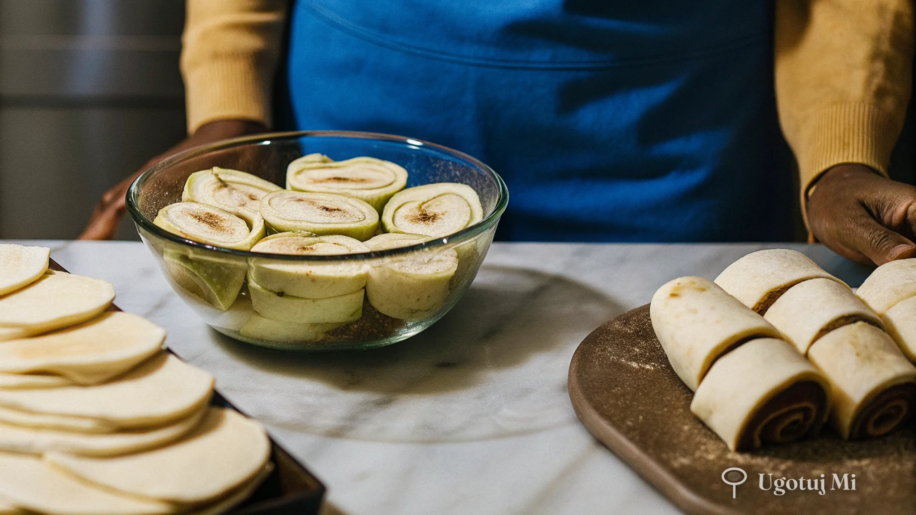 Pokrojone jabłka z cynamonem i rozwałkowane ciasto na blacie | ugotujmi.pl
